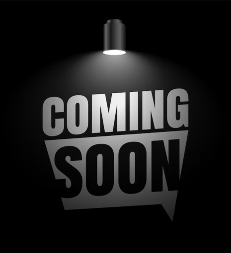 Black background with a spotlight above illuminating bold, silver text that reads COMING SOON in large capital letters.
