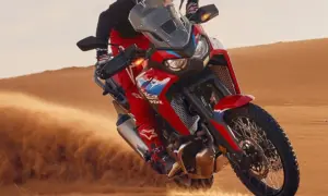 Rider on a Honda Africa Twin CRF1100 carving through desert sand