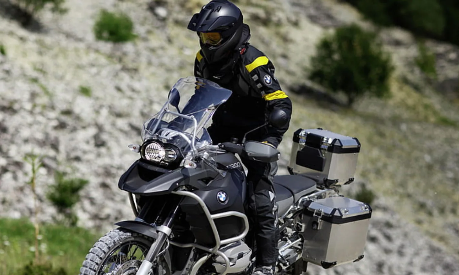 Rider on a BMW R 1200 GS Adventure with aluminium panniers on a mountain trail