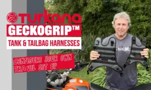Man holding up a Turkana GeckoGrip tank and tailbag harness in a garden