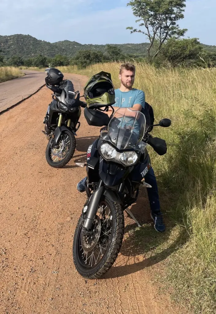 Jean Murphy sitting on his Triumph Tiger 800 XCx on a dirt road