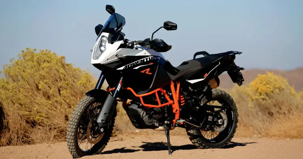 KTM 1190 Adventure R parked on a dirt road among dry bushes