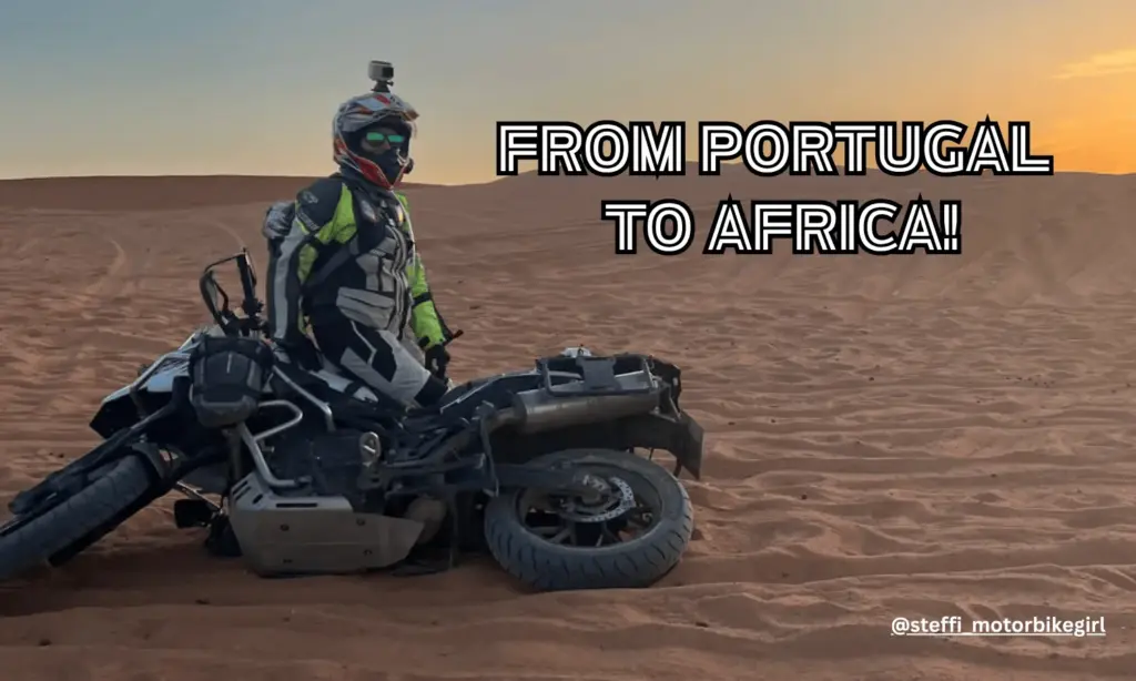 Rider beside a fallen adventure bike in desert sand, captioned From Portugal to Africa