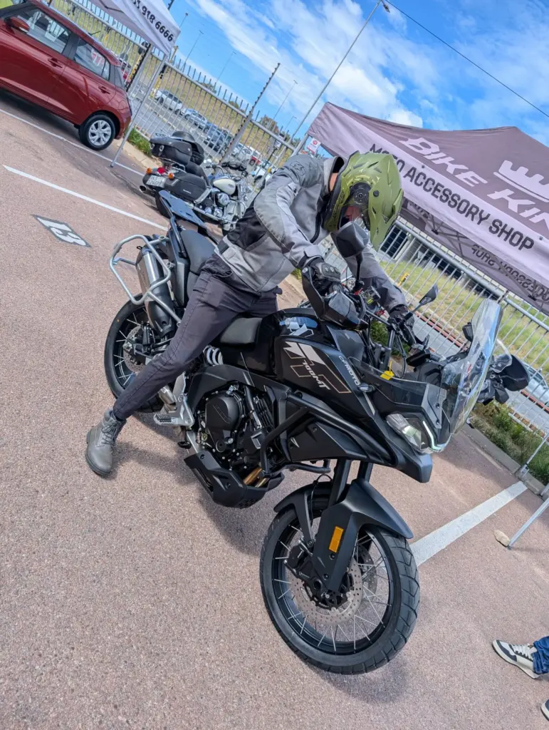 Rider on a black CFMOTO adventure bike at a dealer open day