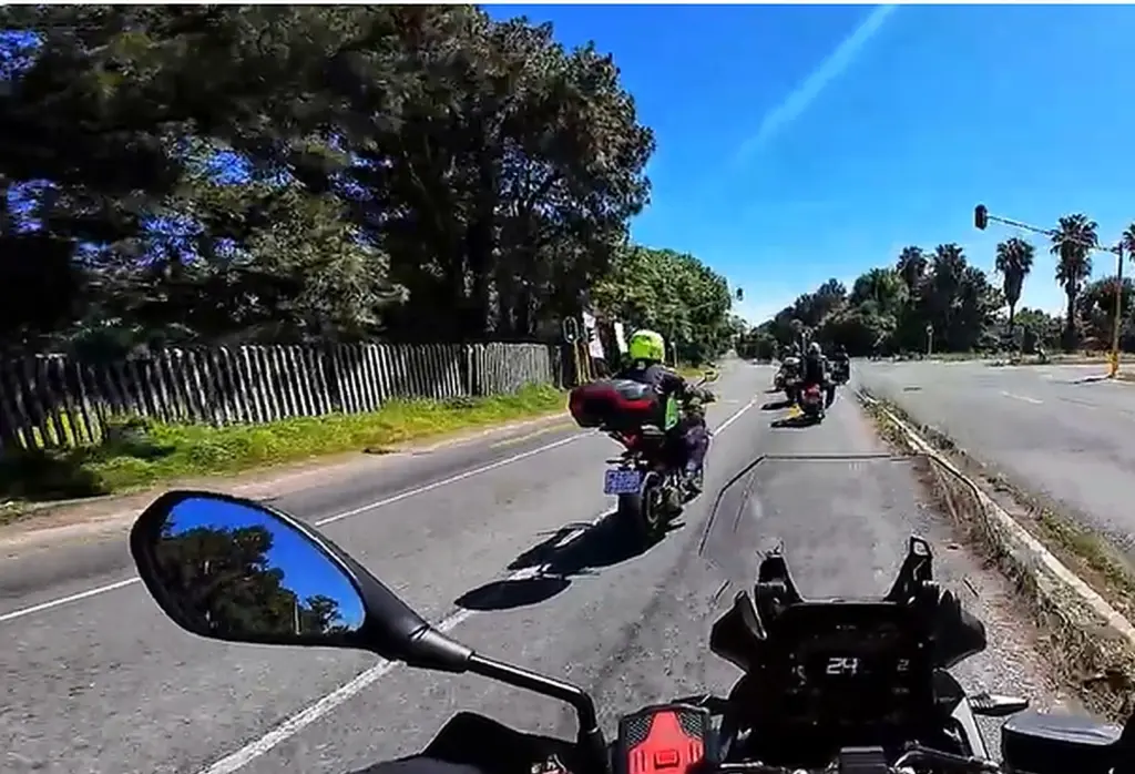 A group of Synergy Social Rides motorcyclists travelling together along a tree-lined road in Gauteng.
