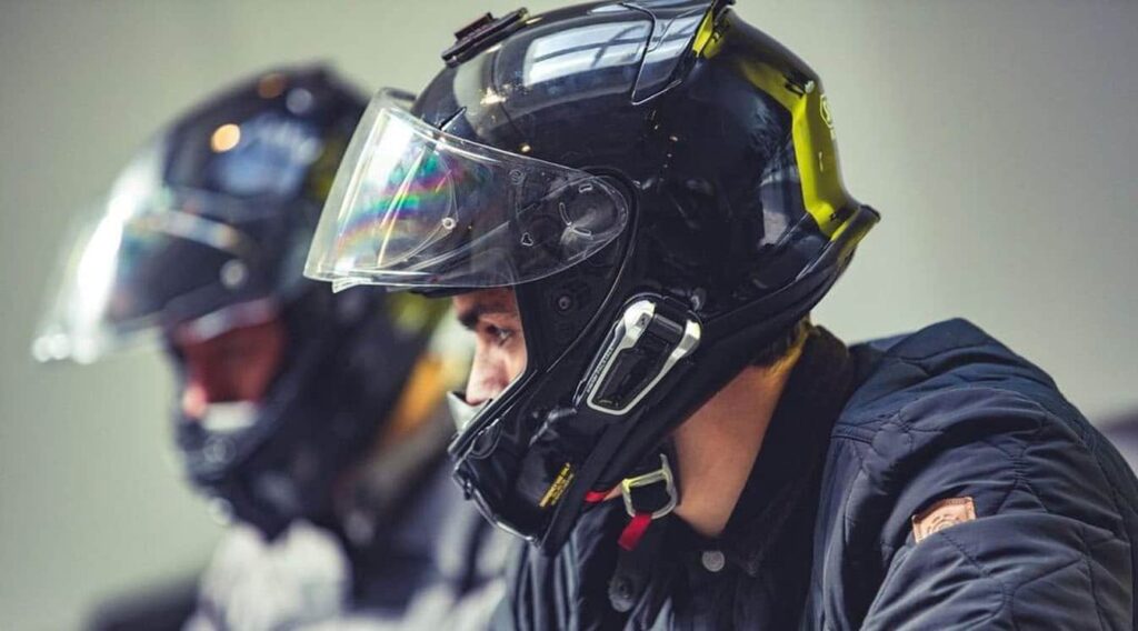 Two riders wearing helmets fitted with motorcycle intercom units