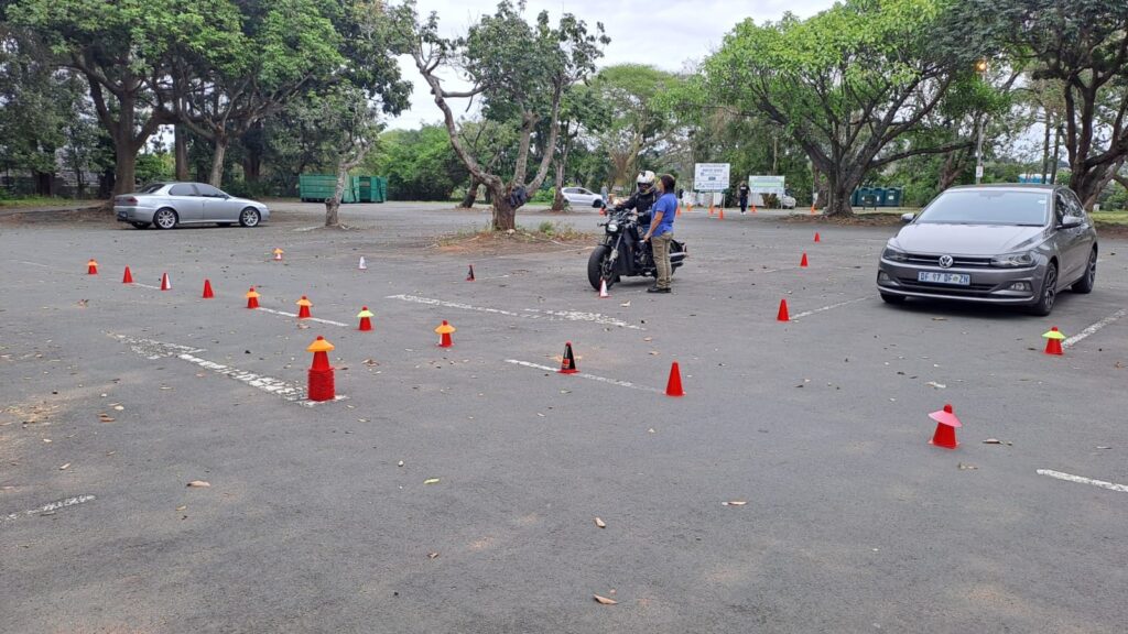Learner and instructor among training cones at the Ubuntu Motorcycle Training School practice area in Westville